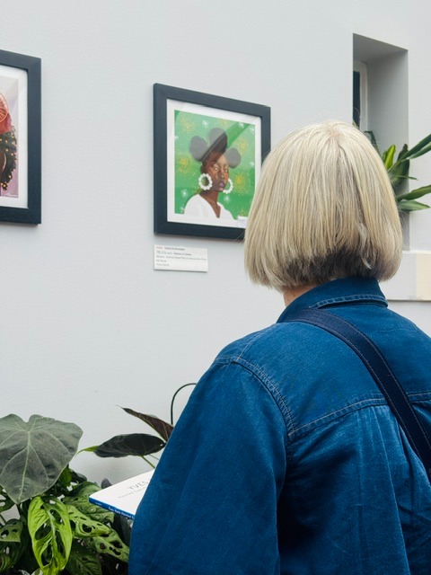 Visitor experiencing Aishat Arowosegbe's portraits at Saltaire Arts Trail